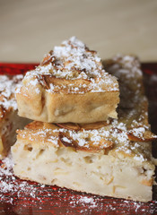 Homemade sweet apple pie with cinnamon and and powdered sugar.