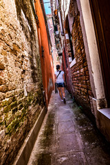 Woman walks through the narrow streets of Venice