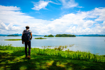 Fototapeta na wymiar man traveling walking with backpack at national park in the jungle day time sun shine on holiday at weekend relax fresh on background nature view