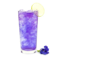 Butterfly pea juice with ice in transparent cup serve on wooden table with flower.