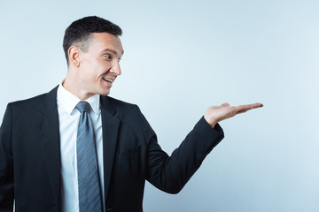 Positive delighted businessman looking at his palm