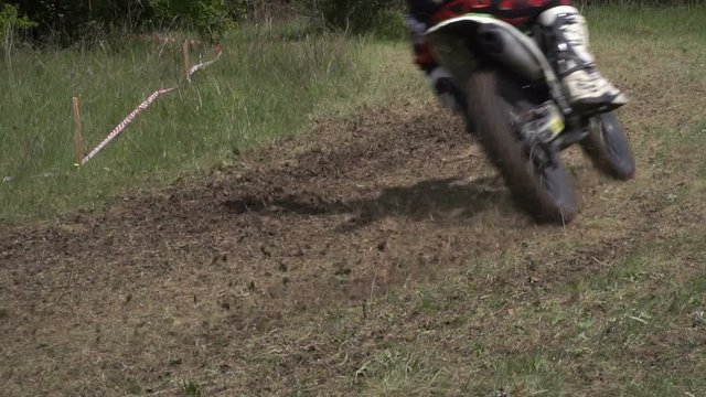 Motorbike speeding on dirt close up. Dirt flying behind the motocross racer while speeding on track. Slow motion