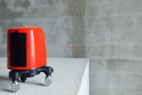Laser level instrument on the aerocrete brick on construction. Focus on the wall