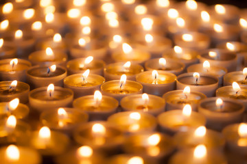 Soft dreamy image of bright candlelight from burning tea light candles. Christmas background image.