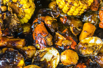 Cajun food with corn and crabs and black pepper sauce