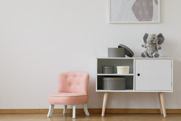 Pink chair next to white shelf