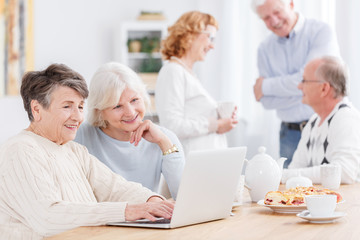 Obraz premium Two senior women using laptop