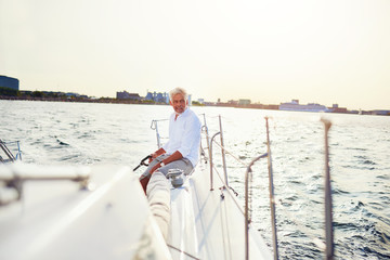 Mature man out sailing his yacht on a sunny afternoon