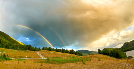 Double rainbow over green forest in summer