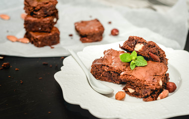 Sliced homemade brownies on white plate. Served on rectangle white plate. Favorite chocolate dessert for chocolate lover. Sweet and moist of cocoa taste. Top view.