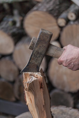 Axe with hand, Heap of chopped wood, close up on the axe, cutting firewood and preparing winter wood