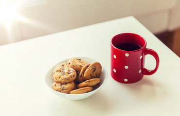 close up of oat cookies and red tea cup on table