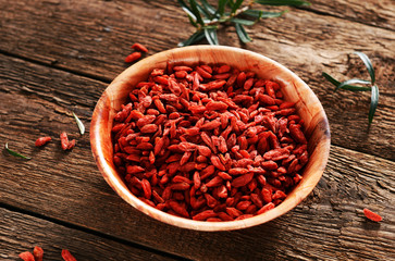 Dried goji berries on wooden background
