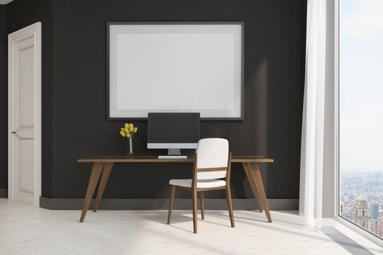 Black home office with a framed poster, side