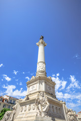 The twenty-three meter tall column with a statue of Dom Pedro IV in Praca Dom Pedro IV or Rossio Square in Lisbon downtown, Portugal, Europe. Sunny day in blue sky. Cpy space.