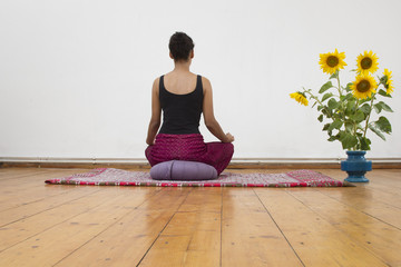 Junge Frau meditiert auf Meditationkissen - 170862190
