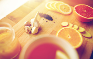 ginger tea with honey, citrus and garlic on wood