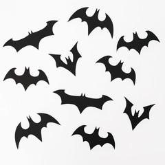 Halloween pattern made of handmade black paper bats for Halloween holiday on white background. Flat lay, top view.