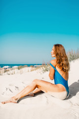 Fototapeta na wymiar Young woman in swimwear with sand on tropical beach. Summer woman body