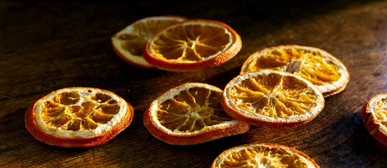 Dried orange slices on a rustic wood background. Close up texture detail with selective focus.