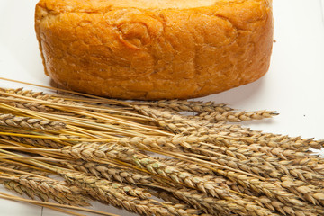 Rustic Bread and wheat on a white wooden background