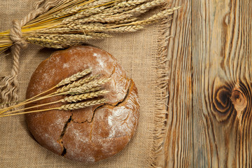 Wheat and traditional Ukrainian bread on a wooden background