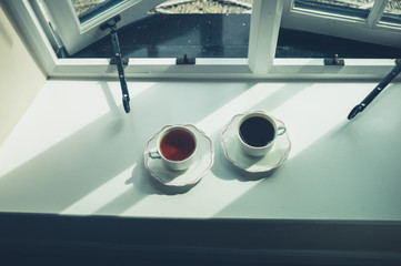 Cup of coffee and tea by the window