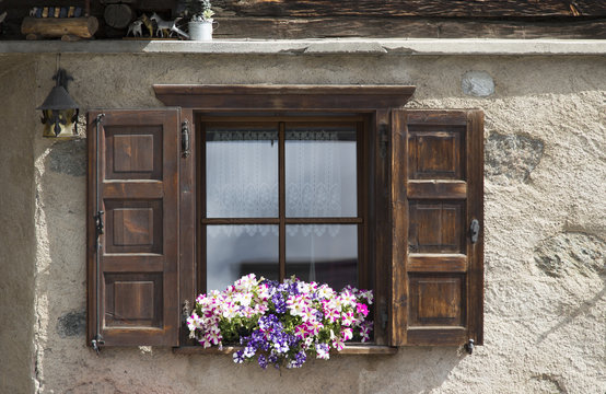 Fototapeta Window open shutters with flowers on windowsill