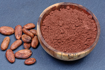 Cacao beans with powder on slate