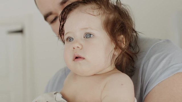Father hold little baby girl after bathroom
