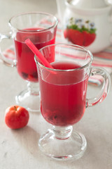 Fresh berry drink in a glass cup on a white table. Selective focus
