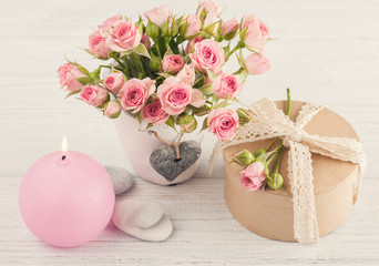 Pink roses in concrete pot with candle