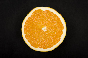 Half of an orange on a dark background