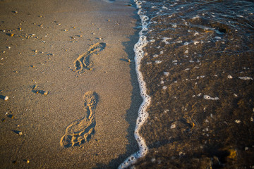 Human footprint by the sea on the sand.