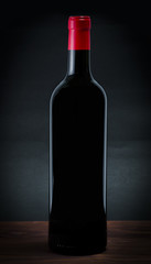 Bottle of red wine on a dark grey background