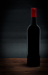 Fototapeta na wymiar Bottle of red wine on a dark grey background