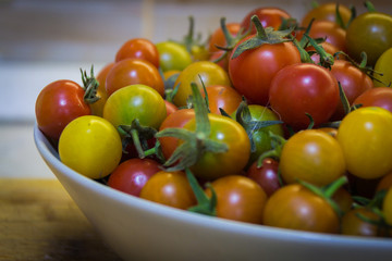A plate of red and yellow cherry tomatoes.