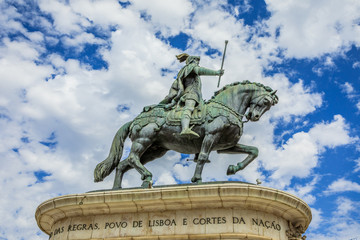 Equestrian statue of King John I in popular Praca da Figueira in the blue sky with clouds. Lisbon, Portugal, Europe.