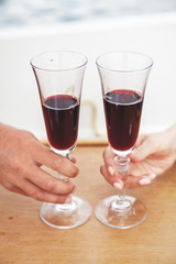 Romantic date. Two glasses of wine in hands close up