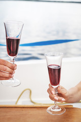 Romantic date. Two glasses of wine in hands close up