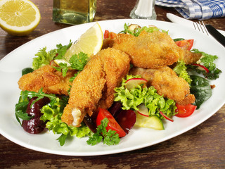 Backhendl mit Zitrone auf Salat
