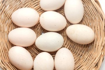 raw dirty duck eggs in basket on white background