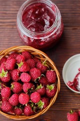 Raspberries and raspberry jam in a wooden basket  