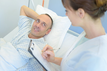 Fototapeta premium nurse with clipboards visiting patient