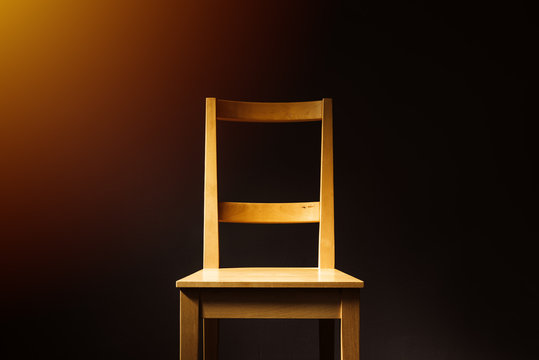 Empty wooden chair in dark room