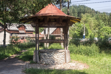 Ancient stone draw-well at Carpathian village in Romania