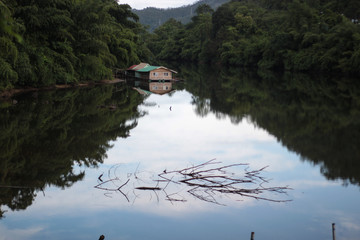 little raft house on river in forest