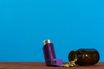 Asthma inhalers with medicines on a beautiful blue background. Bottle pills.Concept of asthma.