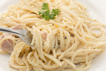 spaghetti carbonara with cream on white plate