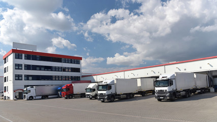 Beladung von LKW´s am Warenlager einer Spedition - Betriebsgelände mit Verwaltungsgebäude 